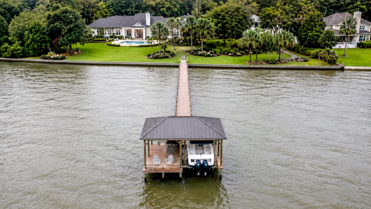 Aerial view of a Mobile Bay waterfront property with a long pier and covered boat lift.